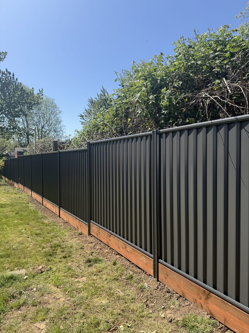 Dark metal privacy fence installed by Gorilla Works