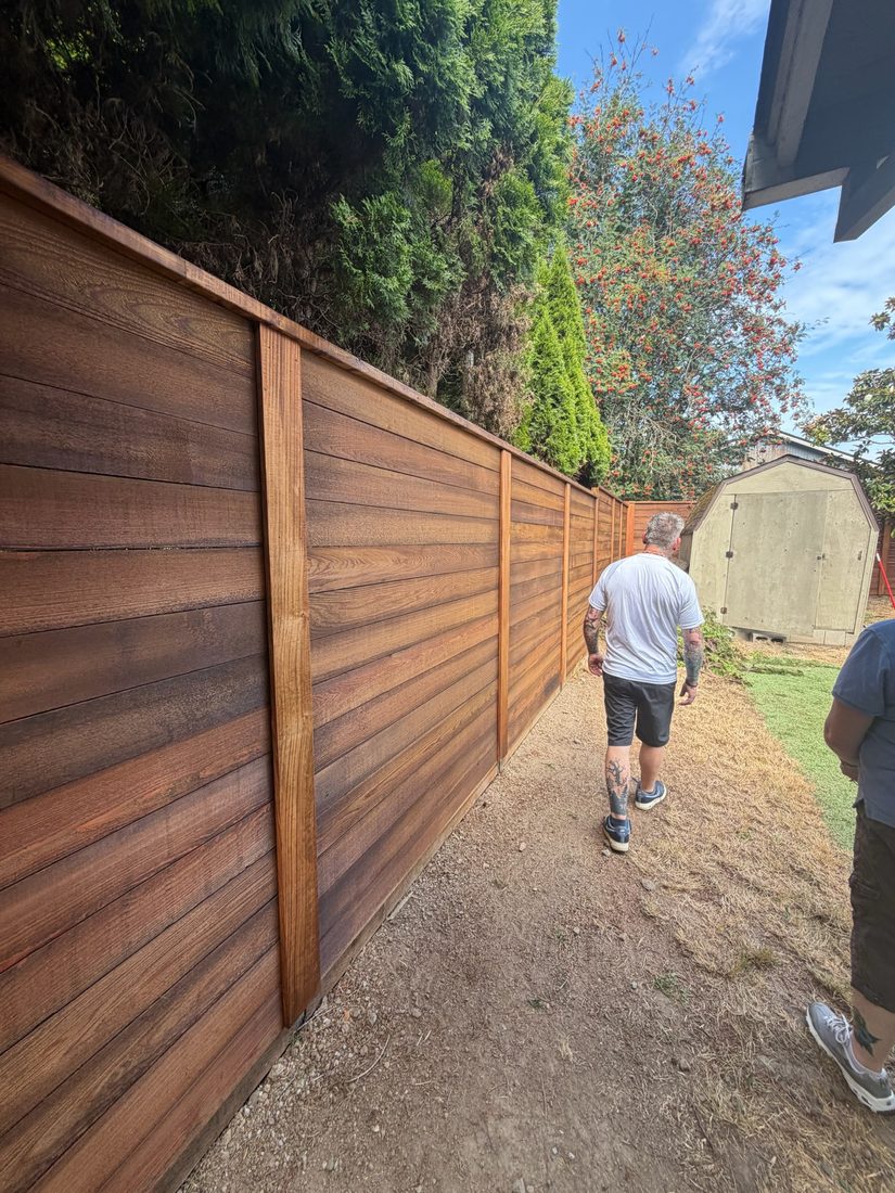Stained horizontal cedar fence along a side yard