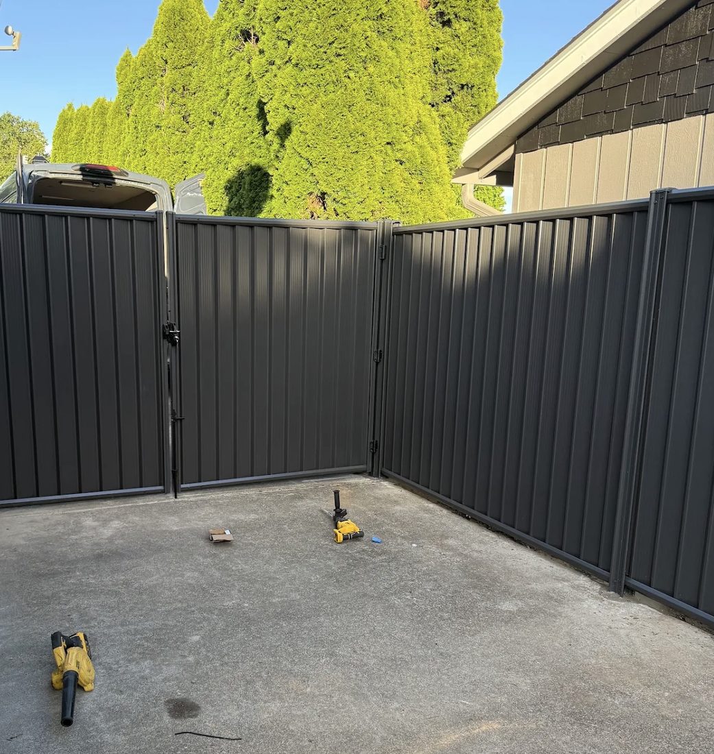 Dark metal fence and matching gate installed by Gorilla Works